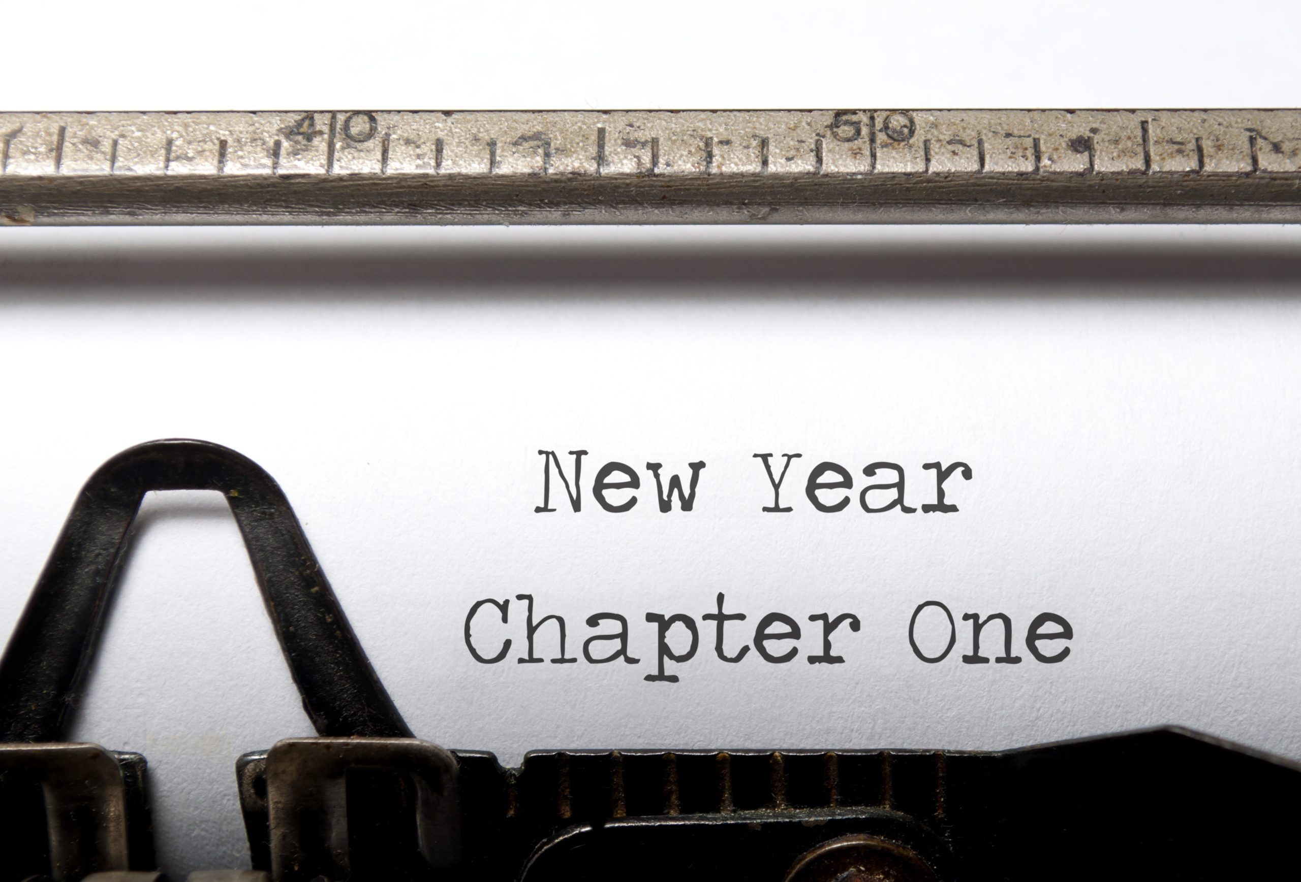 Close up on a page in a typewriter that says "New Year: Chapter One"